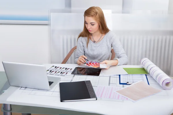 Mujer joven trabajando en el escritorio de la oficina — Foto de Stock