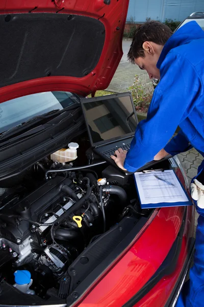 Mechanic laptop gebruikt terwijl het herstel van de auto — Stockfoto