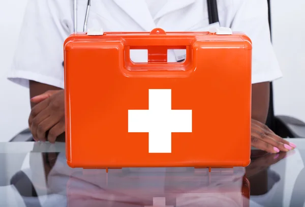 Arzt mit Verbandskasten am Schreibtisch im Krankenhaus — Stockfoto