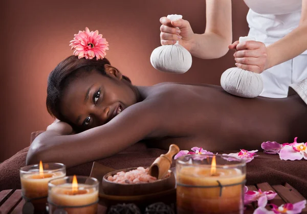 Mujer disfrutando de masaje a base de hierbas en el spa — Foto de Stock