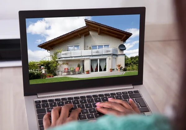 African american vrouw selecteren nieuw huis op laptop thuis — Stockfoto