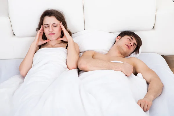 Woman Suffering From Headache While Man Snoring In Bed — Stock Photo, Image