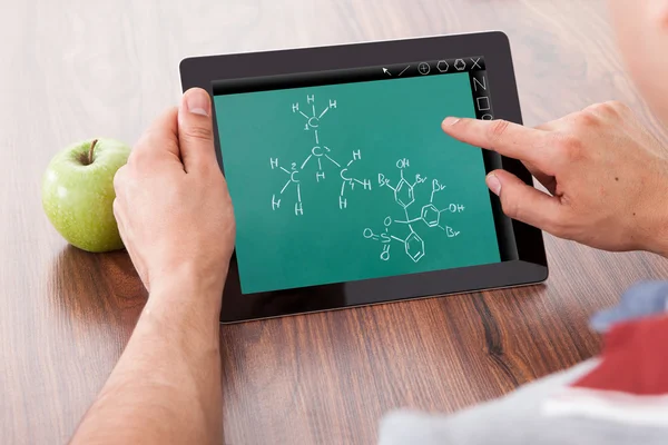 Étudiant étudiant des formules chimiques sur tablette numérique — Photo