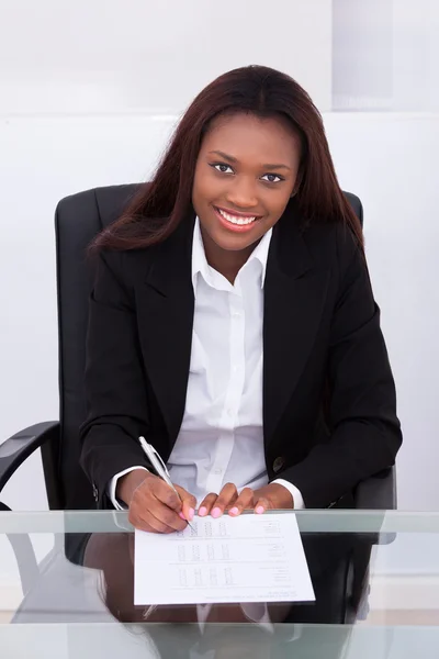Fiduciosa donna d'affari che compila il modulo alla scrivania in ufficio — Foto Stock