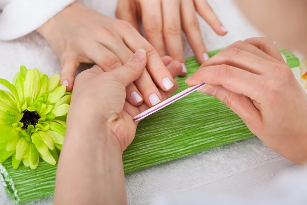 Esteticista arquivando unhas de mulher — Fotografia de Stock