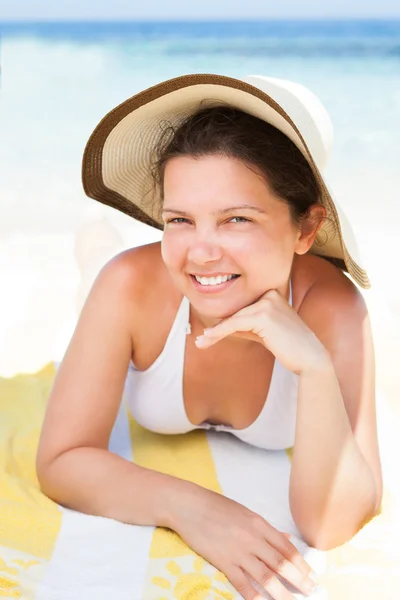 Frau im Bikini-Top auf Strandtuch liegend — Stockfoto