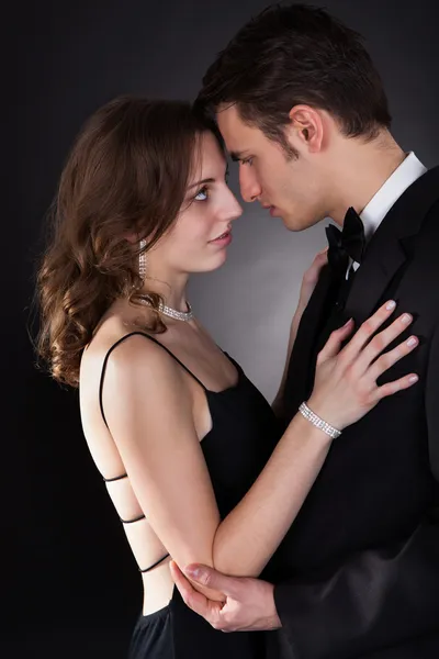 年轻夫妇拥抱在黑色的背景 — 图库照片