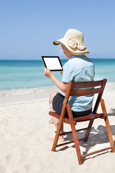 Женщина с цифровым планшетом на пляже — стоковое фото