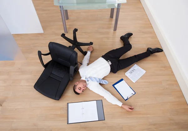 Empresário caído da cadeira do escritório — Fotografia de Stock