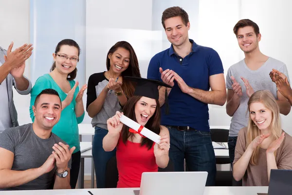 Estudantes batendo palmas para colega de classe Holding Grau — Fotografia de Stock