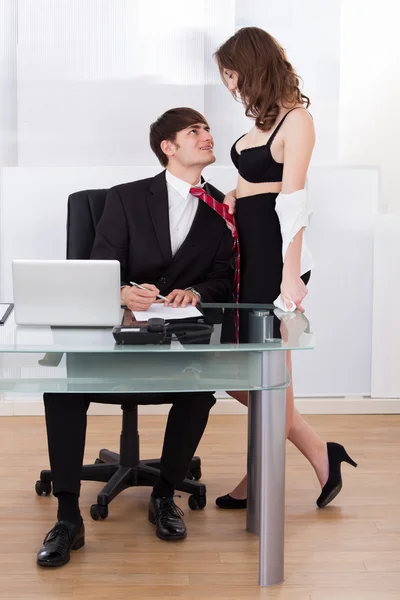 Mulher de negócios não vestida puxando chefe para o auto no escritório — Fotografia de Stock