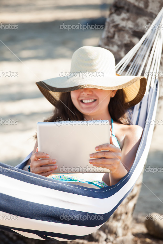 Happy Woman Using Digital Tablet In Hammock