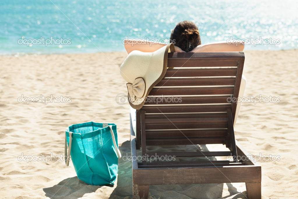 Woman Relaxing On Deck Chair