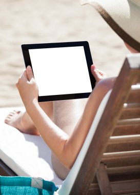 Dijital tablet plaj sandalye kullanan kadın