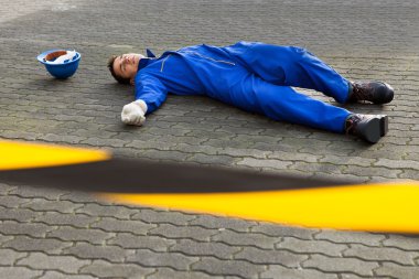 Young Unconscious Technician Lying On Street clipart