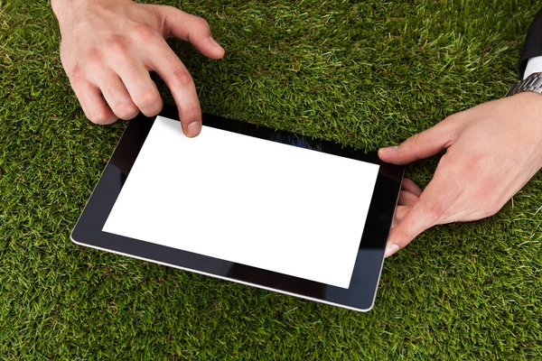 Geschäftsmann nutzt digitales Tablet auf Gras — Stockfoto