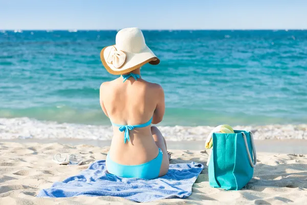 比基尼泳装躺在沙滩巾享受海景房上的女人 — 图库照片