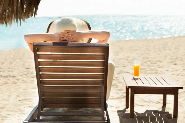 Kobieta relaks na leżaku na plaży — Zdjęcie stockowe