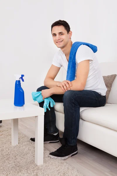 Человек с салфеткой и перчатками дома — стоковое фото