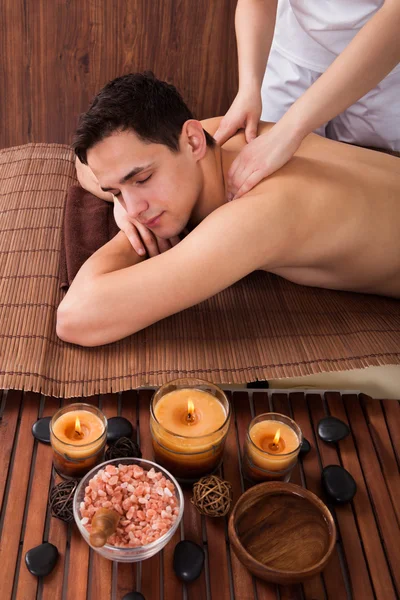 Entspannter Mann erhält Schultermassage im Wellnessbereich — Stockfoto