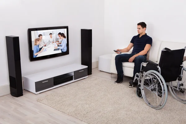 Hombre discapacitado viendo televisión en la sala de estar —  Fotos de Stock