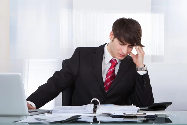 Empresário sofrendo de dor de cabeça ao calcular Finanças — Fotografia de Stock