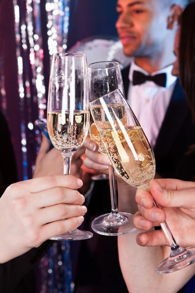 Vänner skålar champagne på nattklubb — Stockfoto