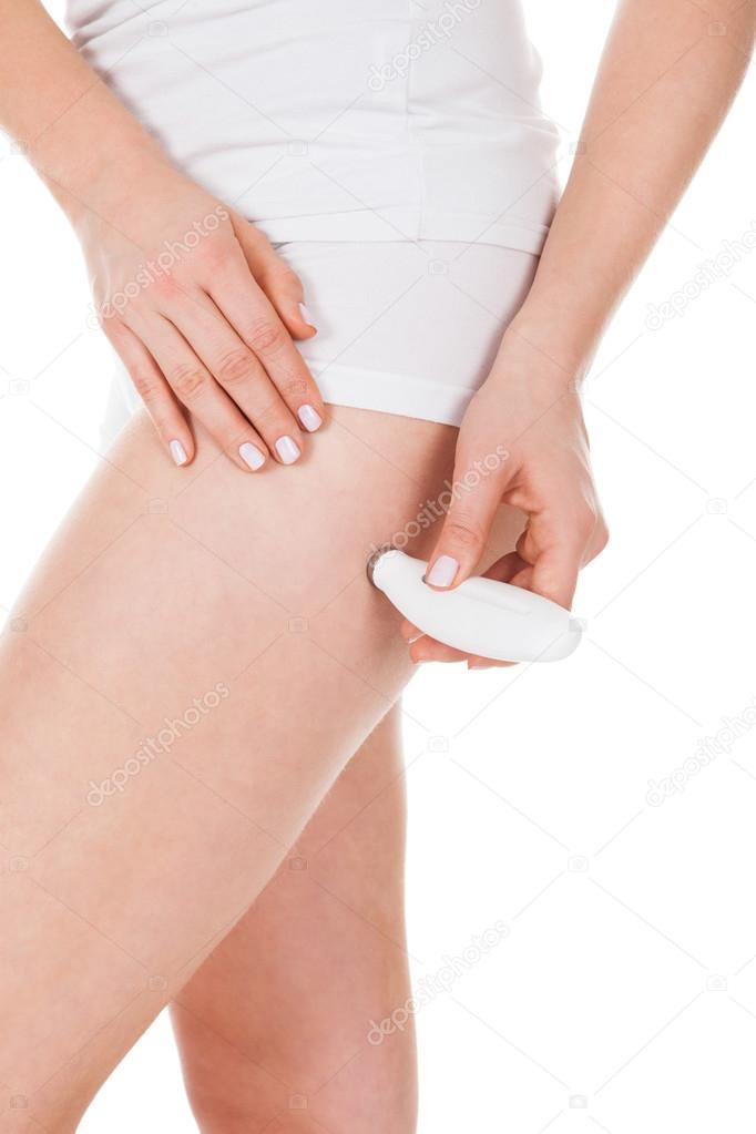 Woman Applying Microdermabrasion On Thigh