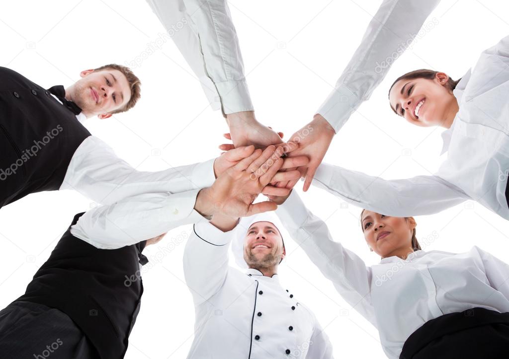 Waiters and waitresses stacking hands