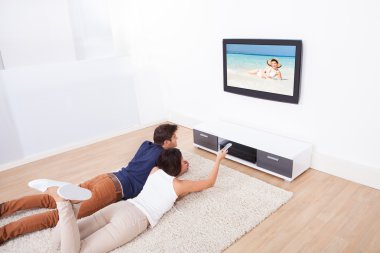 çift evde televizyon izliyor.