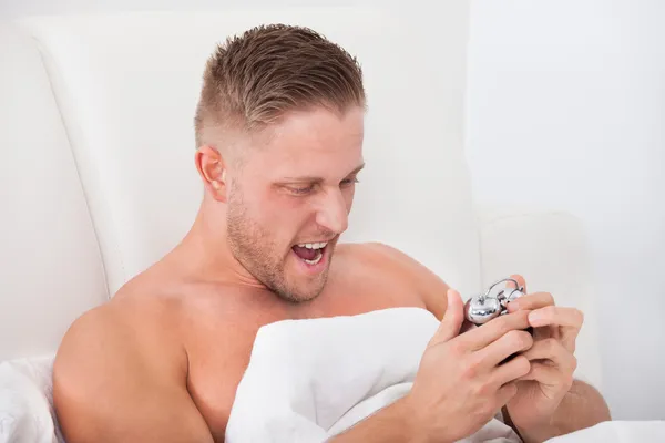 Homem gritando de frustração em seu despertador — Fotografia de Stock