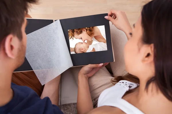 Paar kijkend naar fotoalbum — Stockfoto