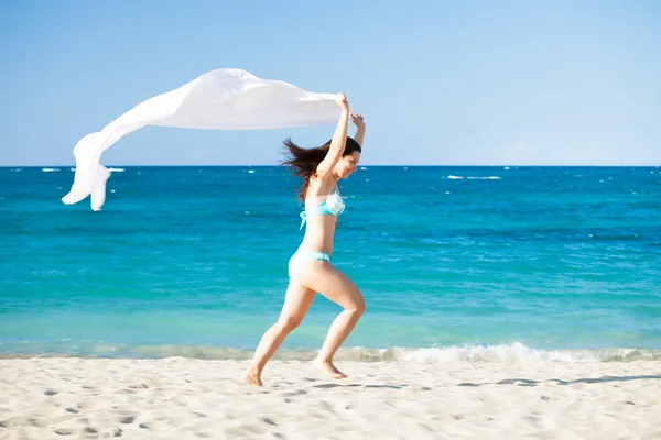 Mujer con sarong corriendo en la playa — Foto de Stock