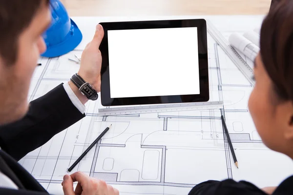 Arquitectos con tableta digital trabajando en el plano — Foto de Stock