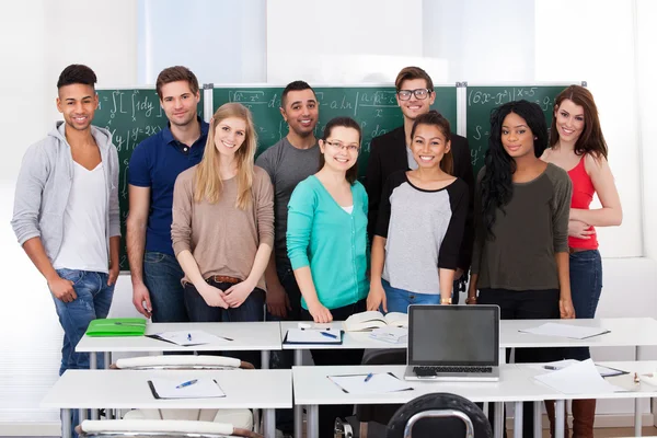 Kendine güvenen üniversite öğrencileri sınıfta birlikte ayakta — Stok fotoğraf