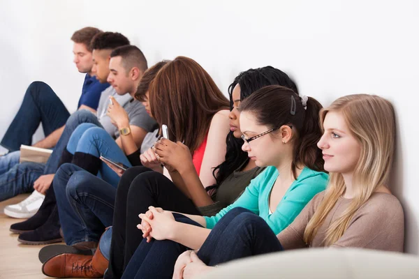 Studenten zitten tegen muur in klas — Stockfoto