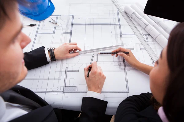 Architects Working On Blueprint At Desk — Stock Photo, Image
