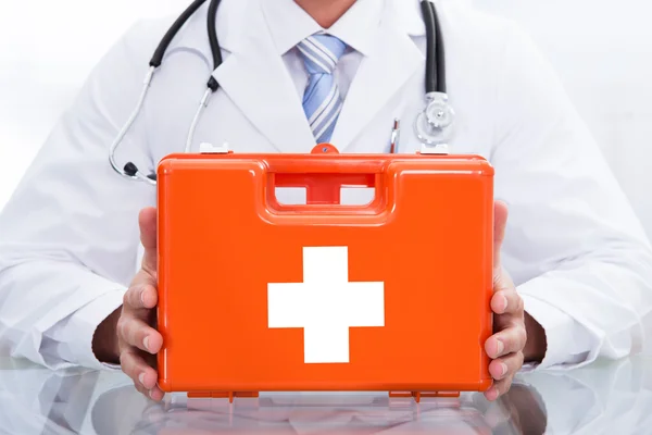 Médico sonriente o paramédico con un kit de primeros auxilios —  Fotos de Stock