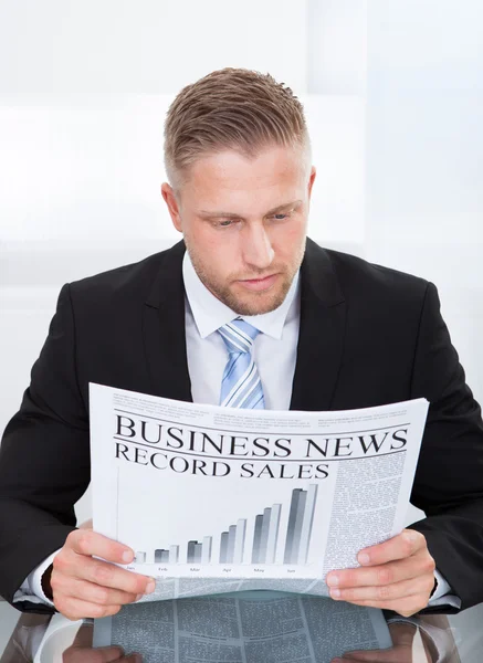 Elegante hombre de negocios guapo estudiando el periódico financiero —  Fotos de Stock