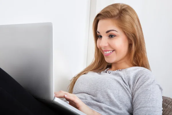 Mujer joven usando el ordenador portátil — Foto de Stock