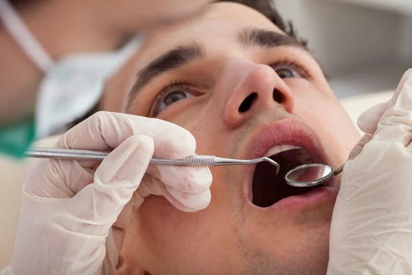 Ausgeschnittenes Bild des Zahnarztes, der den Mund des Patienten untersucht — Stockfoto