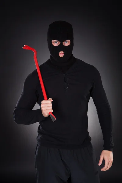 Masked thug or criminal with a crowbar — Stock Photo, Image