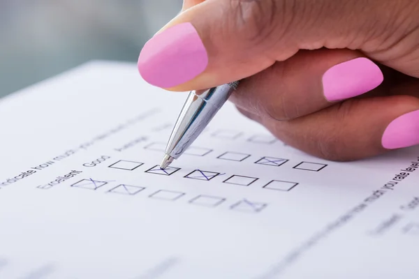 Businesswoman's hand filling customer survey form — Stock Photo, Image