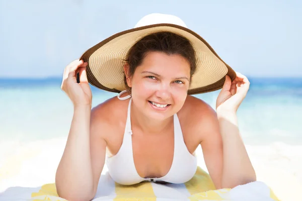 Kobieta w bikini góry leżącego na ręcznik plażowy — Zdjęcie stockowe