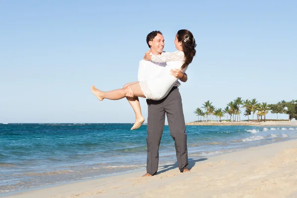 Homem amoroso carregando mulher na praia — Fotografia de Stock