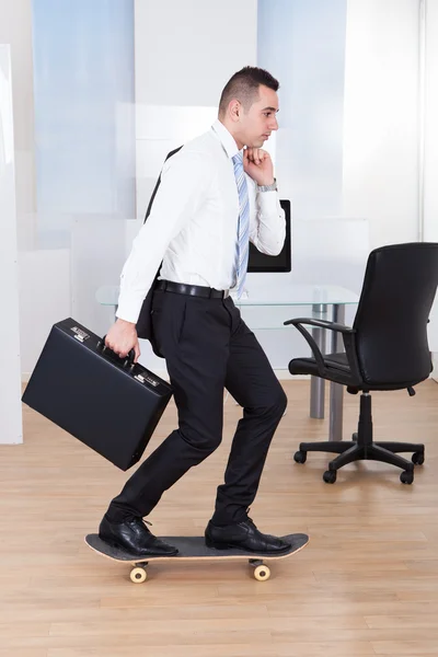 Zakenman op skateboard in office — Stockfoto