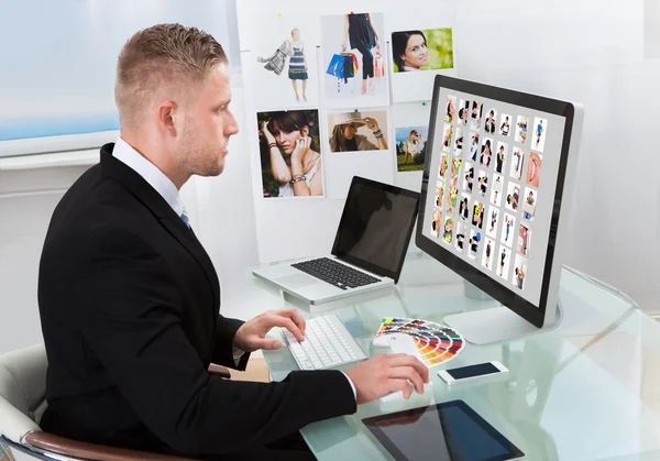 Businessman editing photographs — Stock Photo, Image