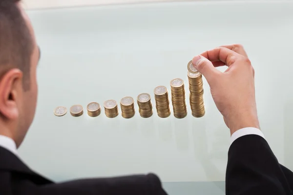 Empresario apilando monedas en orden creciente — Foto de Stock