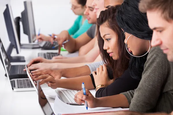 Студентки женского пола используют ноутбук за столом — стоковое фото