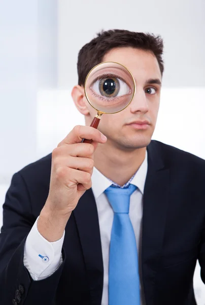 Affärsman tittar genom förstoringsglas — Stockfoto